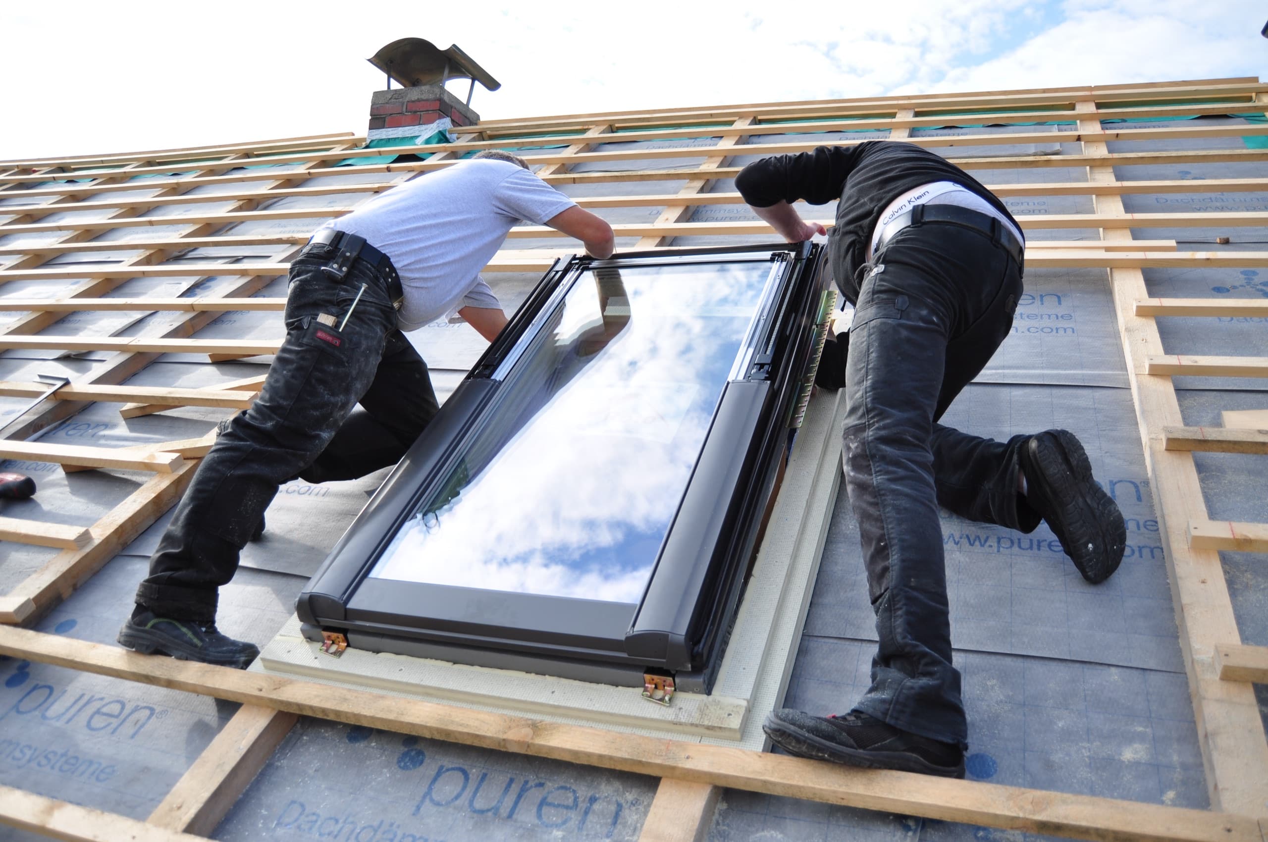 Crew installing a skylight on a roof