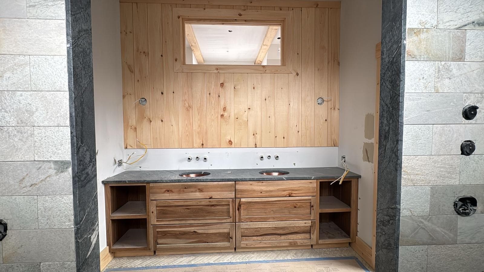 Custom pine double vanity with soapstone top and stone tile shower