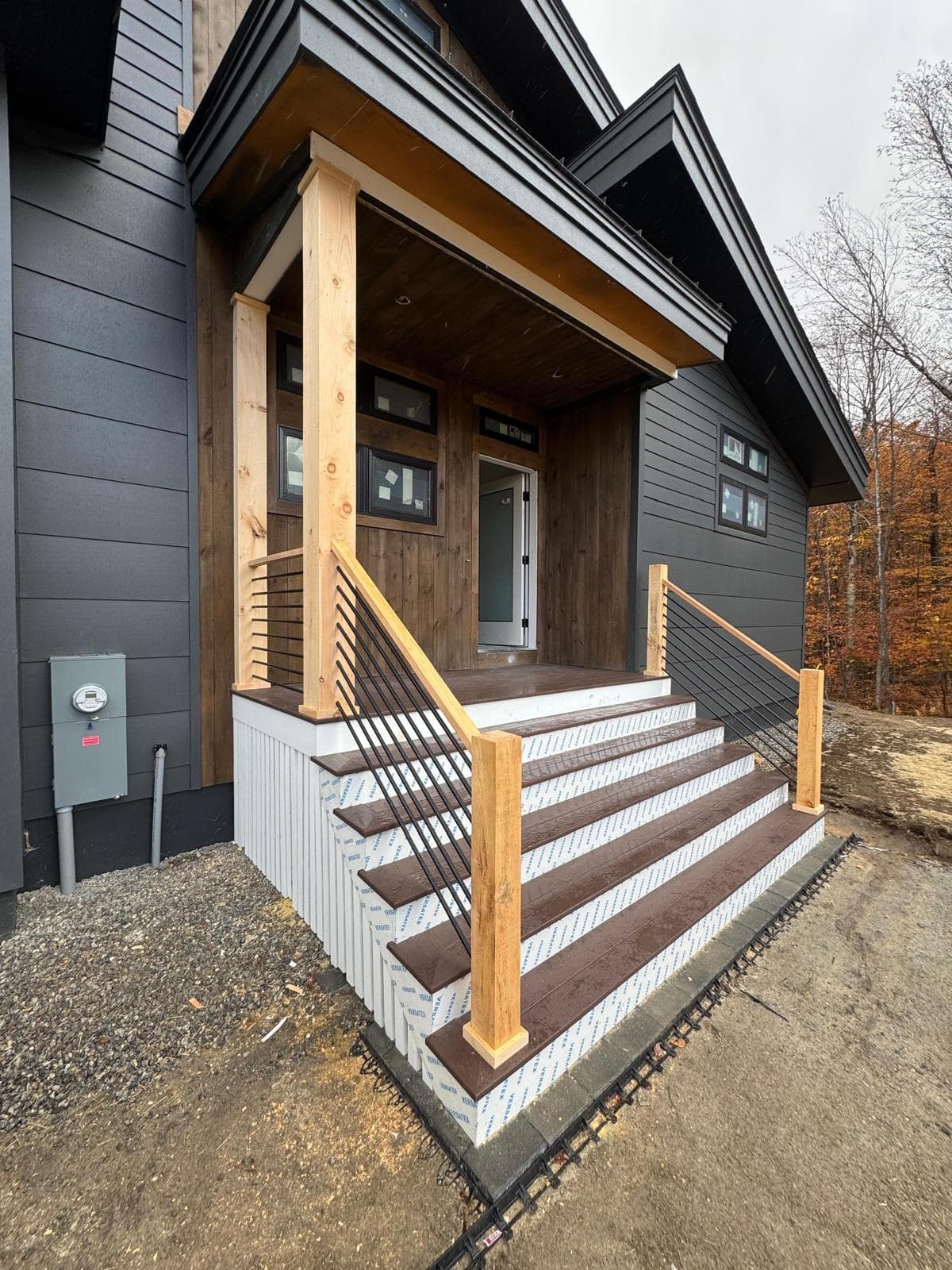 Dark siding home with cedar entry and composite porch