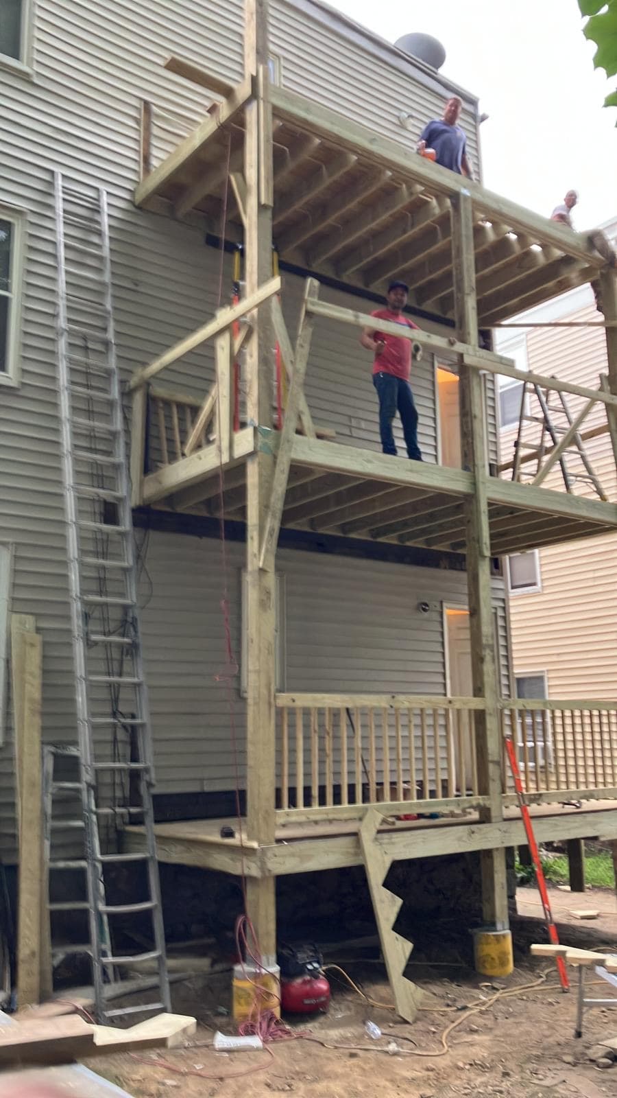 Crew building a multi-level rear porch on a three-family home