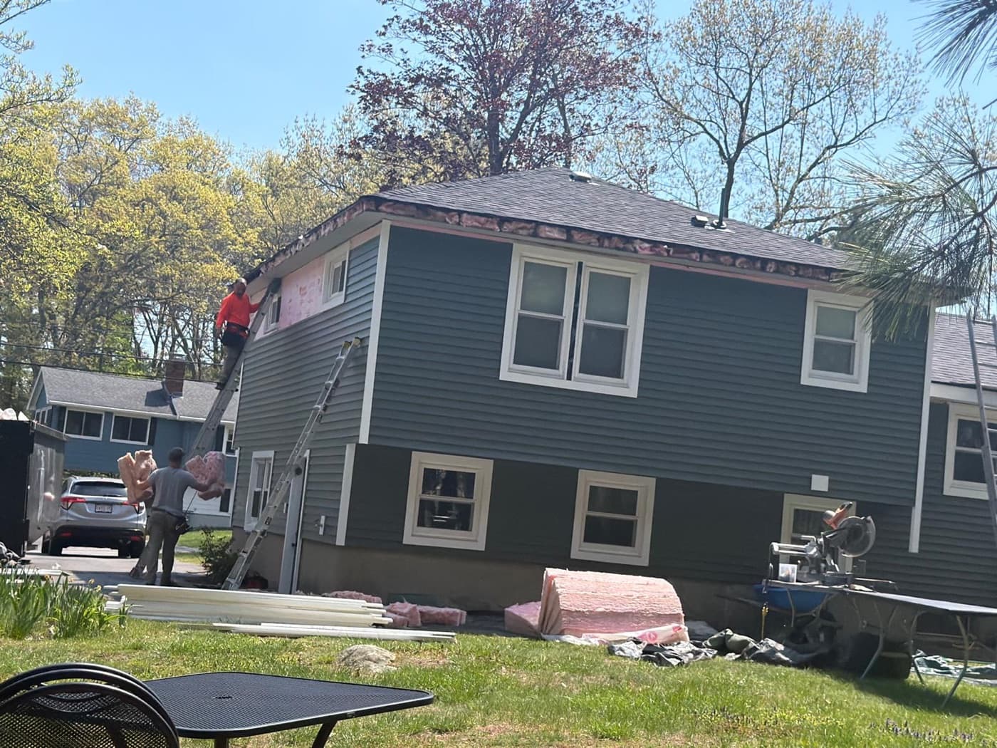 A siding crew installing fascia and new exterior siding on a Greater Boston home