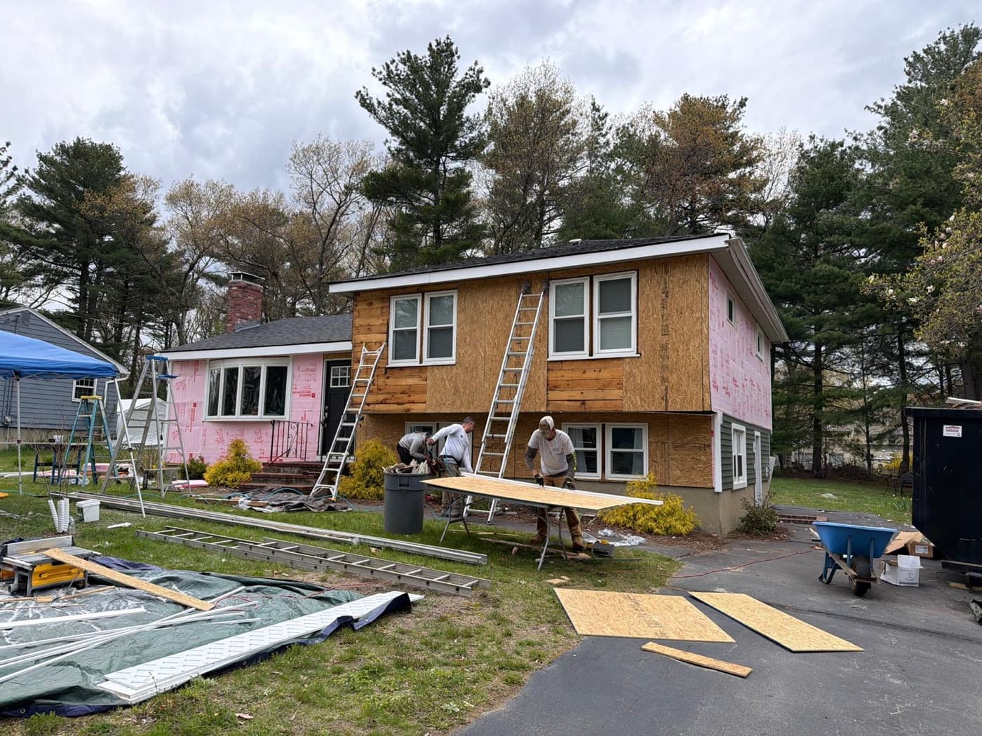 Full crew removing old cedar siding and wrapping before install